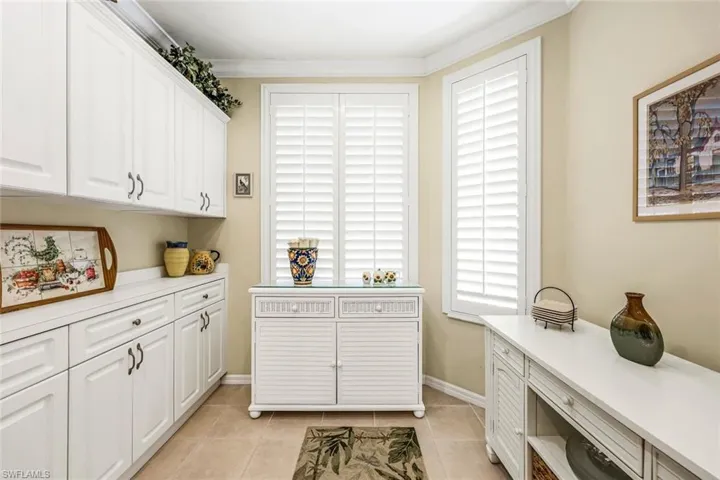 Washroom with ornamental molding and light tile patterned floors