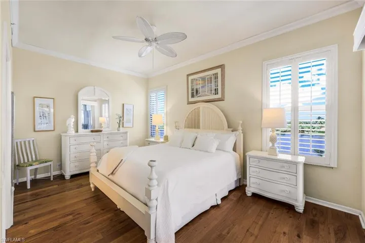 Bedroom featuring ornamental molding, dark hardwood / wood-style floors, and ceiling fan