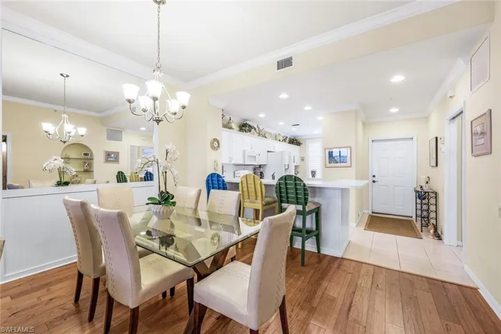 Dining area featuring light tile patterned flooring, a chandelier, and crown molding
