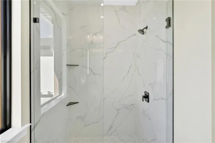 Bathroom featuring a marble finish shower
