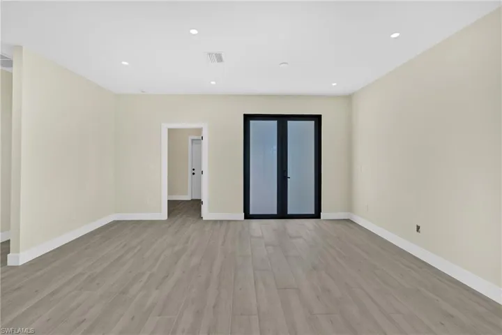 Spare room featuring light wood-style floors, recessed lighting, and french doors