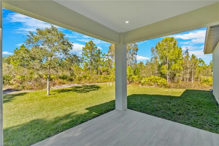 View of grassy yard featuring a patio area