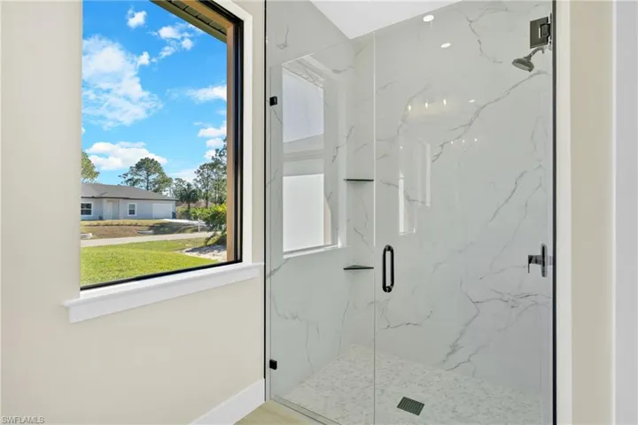 Full bath with a marble finish shower