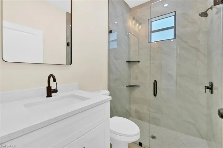 Full bathroom with vanity and a shower stall