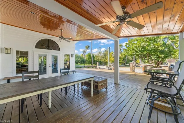 Wooden deck featuring ceiling fan, french doors, and outdoor dining area