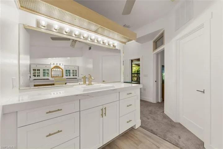 Bathroom with a ceiling fan, vanity, and light wood finished floors