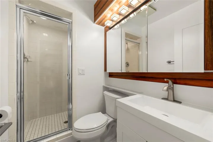 Full bath featuring a stall shower and vanity
