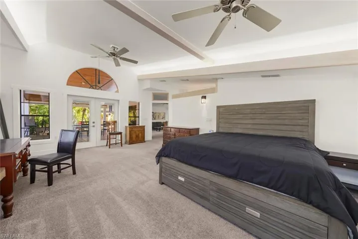 Carpeted bedroom with french doors, access to exterior, and lofted ceiling