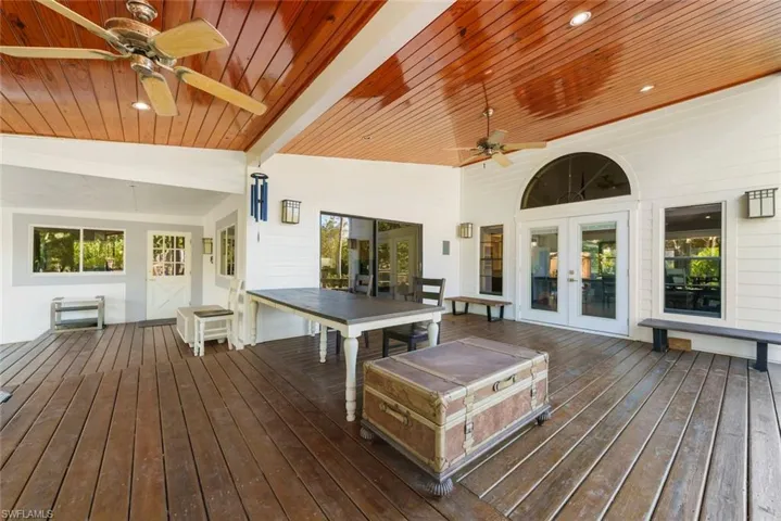 Wooden deck featuring ceiling fan, french doors, and outdoor dining area
