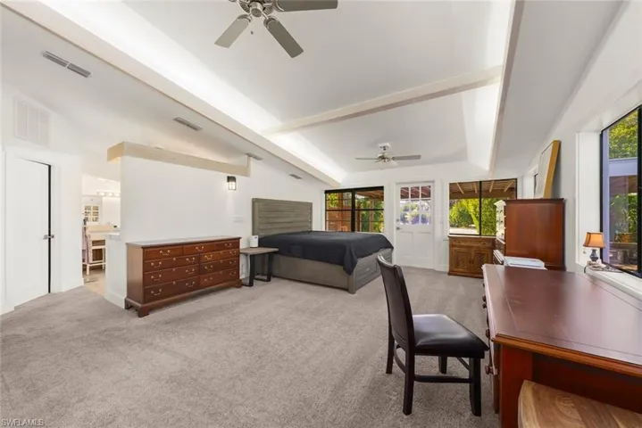 Bedroom featuring light carpet, ceiling fan, beam ceiling, and ensuite bathroom