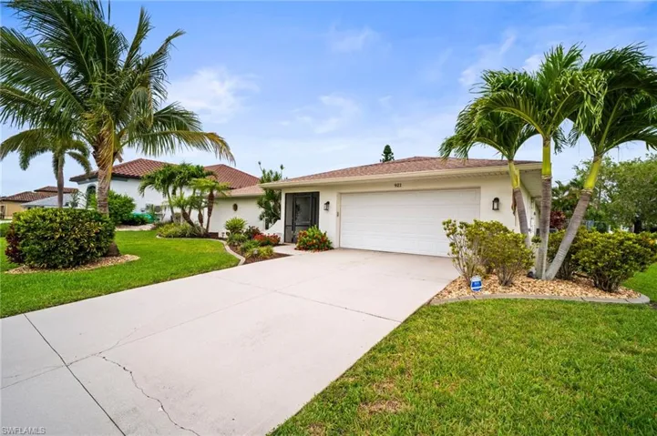 Ranch-style home featuring stucco siding, an attached garage, concrete driveway, and a front lawn