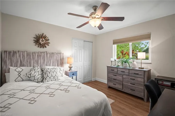 Bedroom featuring a closet, wood finished floors, a desk, and ceiling fan