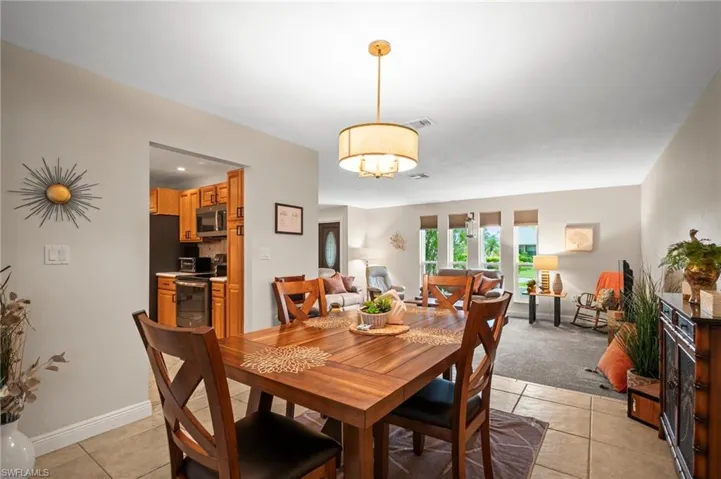 Dining space with light tile patterned floors and a chandelier