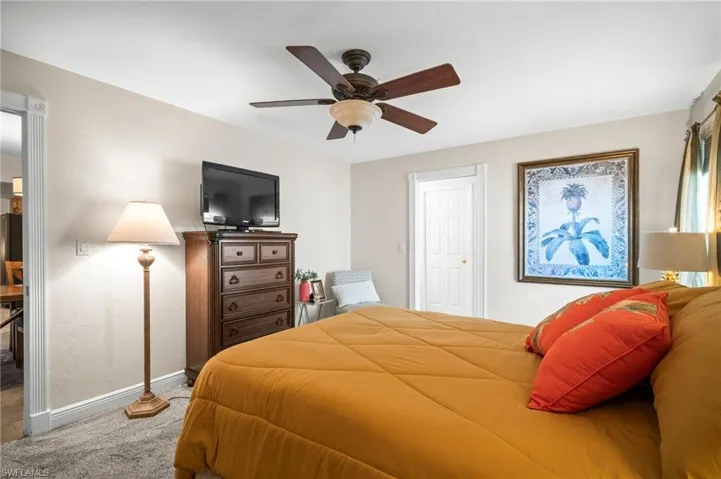Carpeted bedroom featuring baseboards and ceiling fan