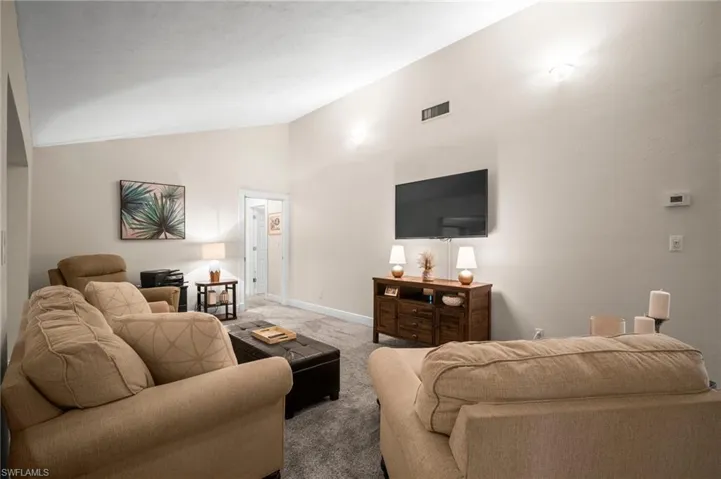 Living area with lofted ceiling and carpet