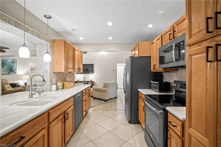 Kitchen with electric range, dishwasher, tasteful backsplash, open floor plan, and recessed lighting