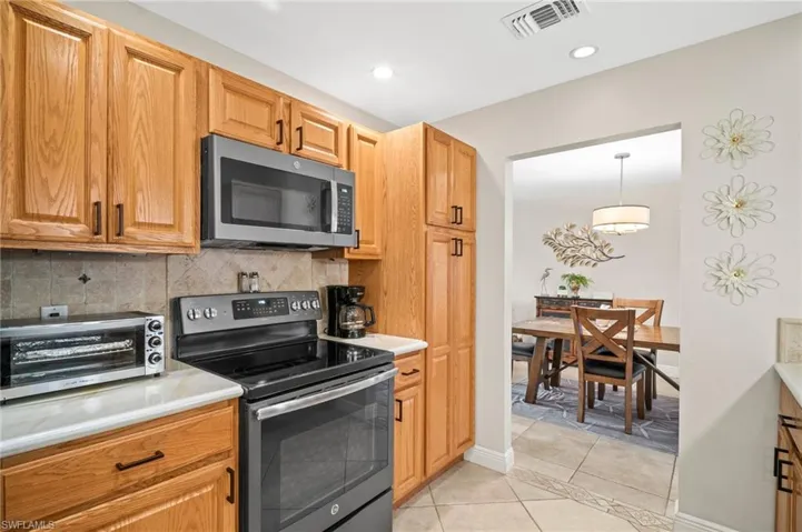 Kitchen with stainless steel appliances, tasteful backsplash, light countertops, light tile patterned flooring, and recessed lighting