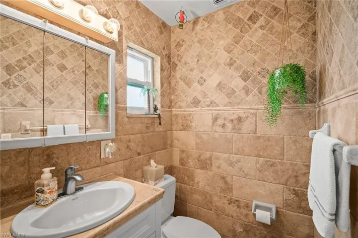 Bathroom with tile walls and vanity