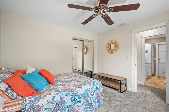 Carpeted bedroom featuring a closet and ceiling fan