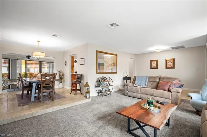 Living room with light colored carpet and ceiling fan
