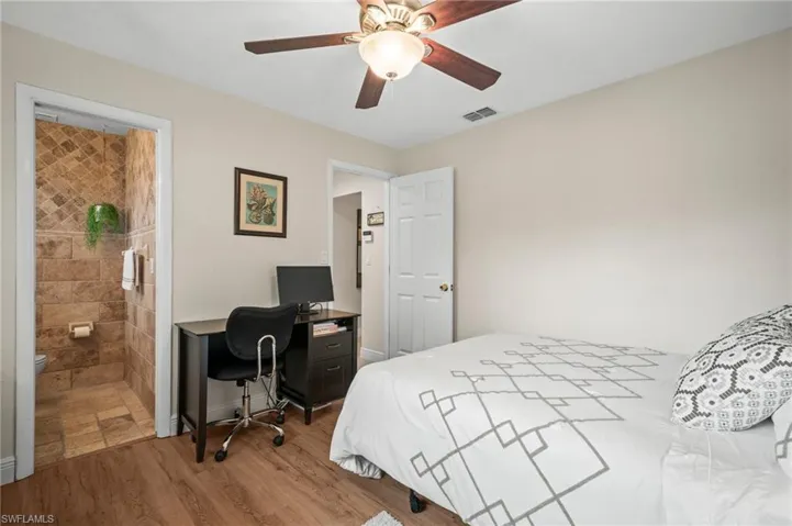 Bedroom with wood finished floors, a desk, and a ceiling fan