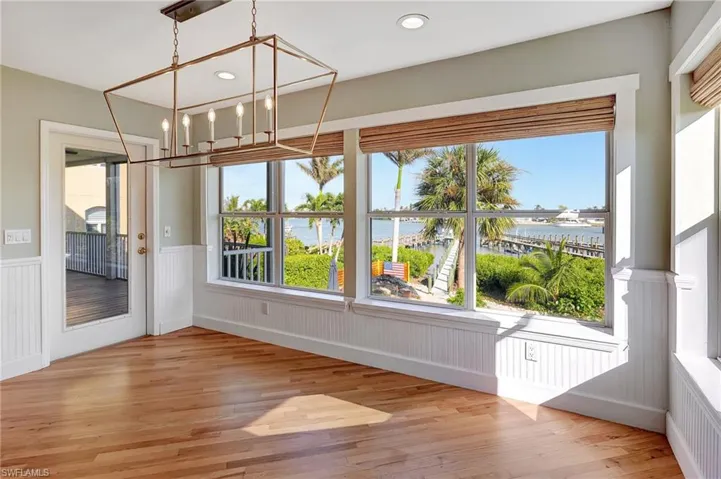 Dining room with a wealth of natural light, a water view, and an inviting chandelier