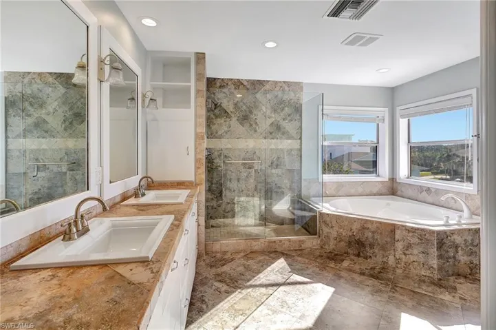 Bathroom featuring dual sinks and separate shower and tub