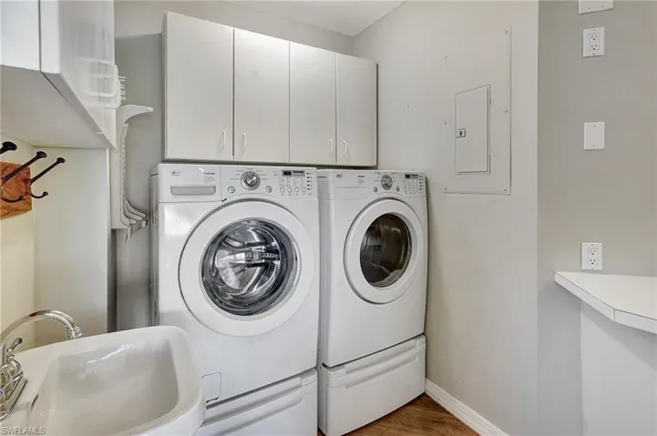 Laundry room with cabinets, sink, washing machine and dryer, electric panel and pantry