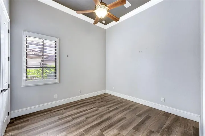 Spare room with ceiling fan, ornamental molding, and wood-type flooring