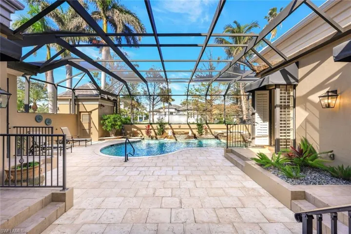 View of pool featuring pool water feature, a patio area, and glass enclosure
