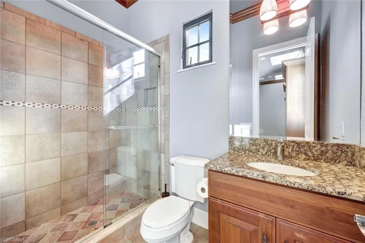 Bathroom featuring walk in shower, crown molding, vanity, and toilet