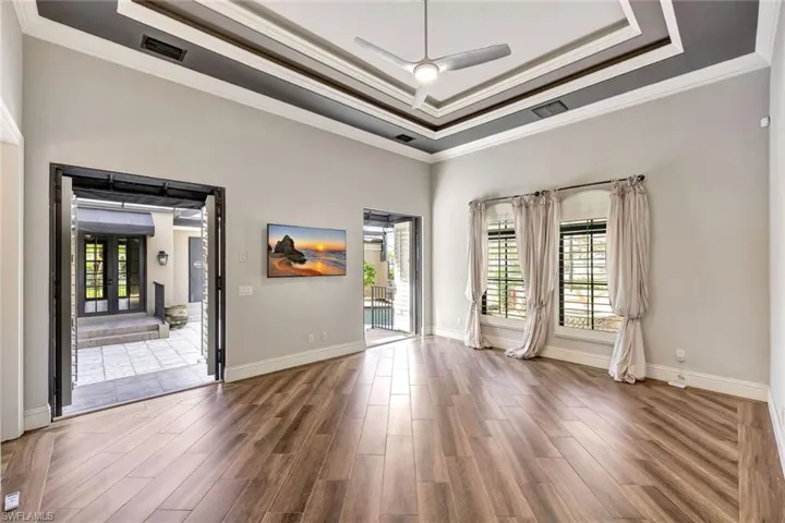 Unfurnished room featuring ceiling fan, a raised ceiling, and crown molding