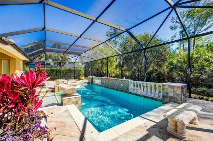 Outdoor pool featuring glass enclosure and a patio area