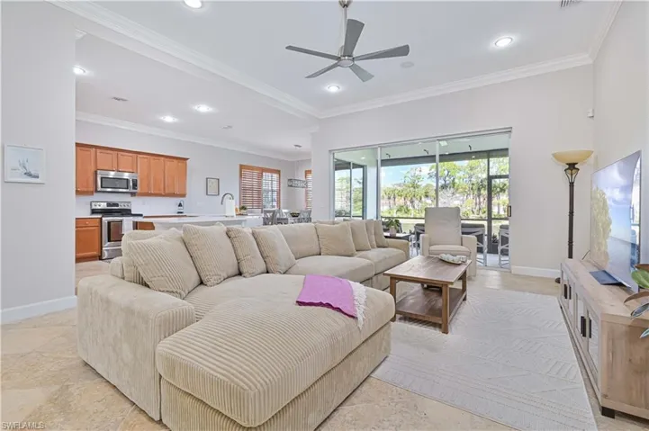 Living room with ceiling fan, crown molding, and recessed lighting