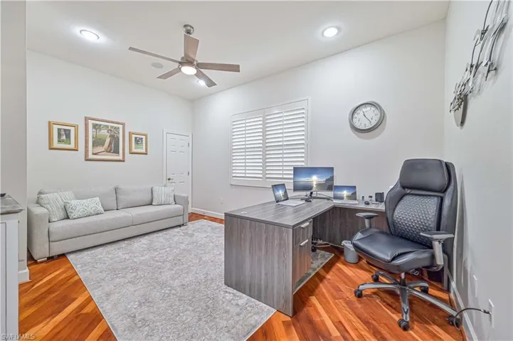 Office area with light wood finished floors, ceiling fan, and recessed lighting