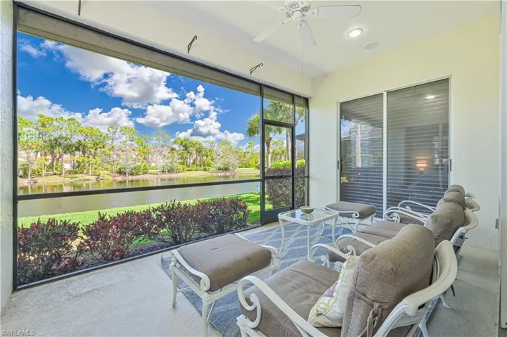 Sunroom with ceiling fan and a water view