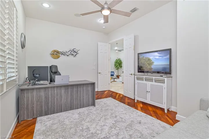 Home office with dark wood-style flooring, a ceiling fan, and recessed lighting