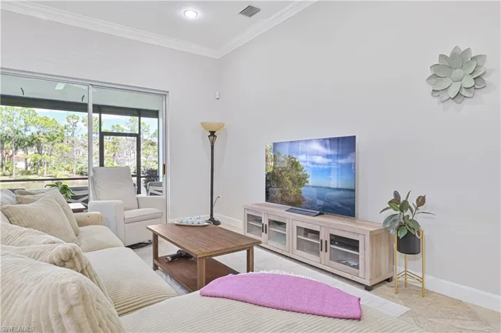 Living area with crown molding and recessed lighting