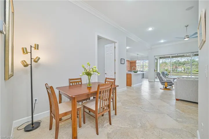 Dining area with ornamental molding, ceiling fan, light stone finish flooring, and recessed lighting