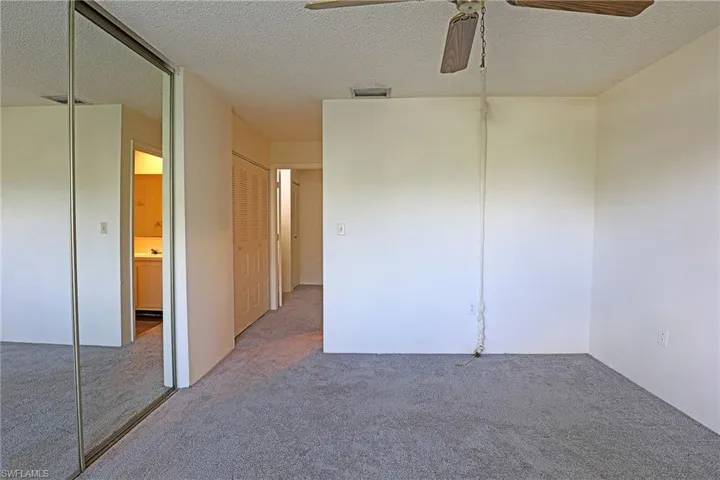 Spare room with a textured ceiling, ceiling fan, and carpet flooring