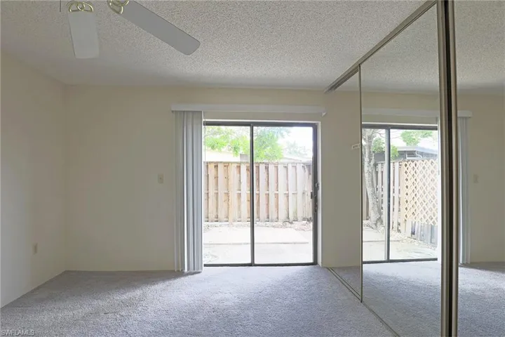 Empty room featuring carpet, healthy amount of natural light, and a textured ceiling