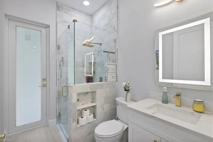 Full bath featuring a shower stall and vanity