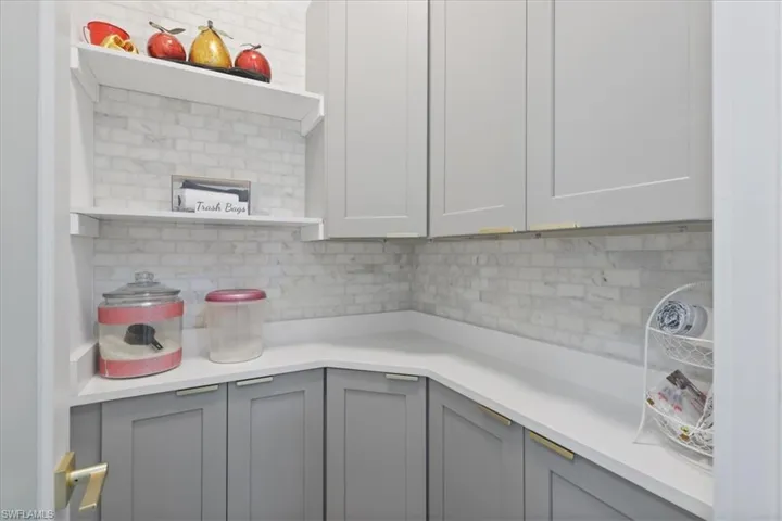 Kitchen featuring gray cabinets, decorative backsplash, open shelves, and white cabinets
