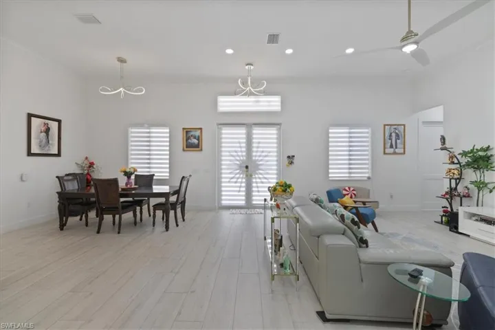 Living room featuring light wood finished floors, recessed lighting, a ceiling fan, and french doors