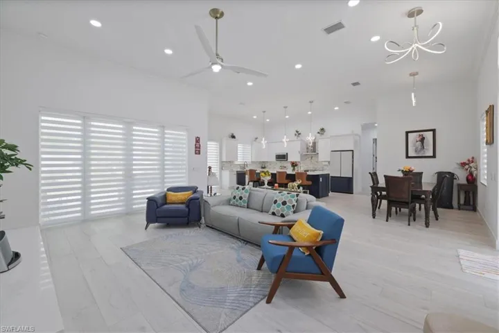 Living area with a ceiling fan, light wood finished floors, recessed lighting, and crown molding