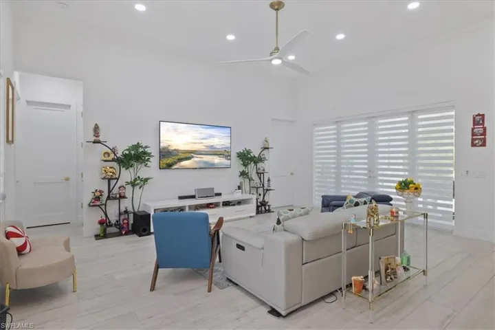 Living area with ceiling fan, recessed lighting, light wood-style floors, and ornamental molding