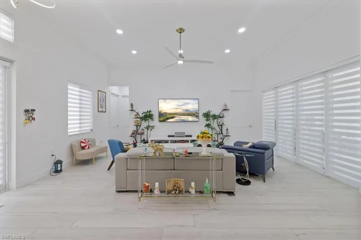 Living room with ornamental molding, ceiling fan, recessed lighting, and light wood-type flooring