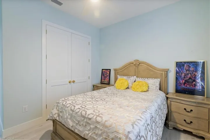 Bedroom with a closet, light wood-style floors, and ceiling fan
