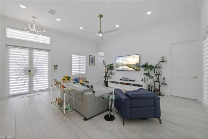 Living area with recessed lighting, ceiling fan, and light wood-style flooring