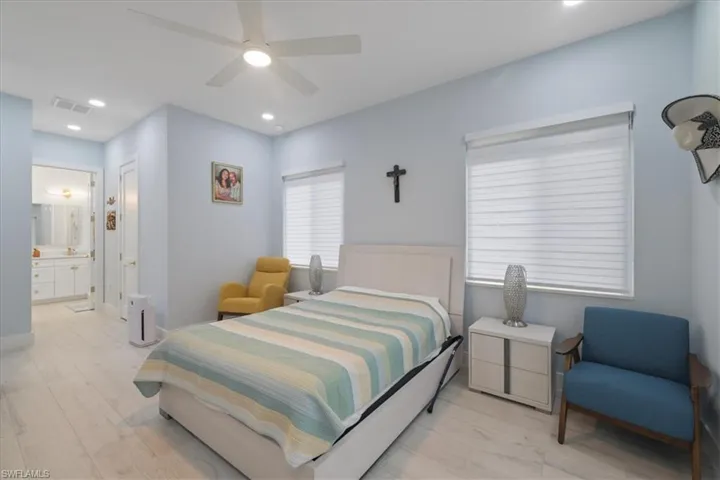 Bedroom featuring light wood-type flooring, recessed lighting, ceiling fan, and ensuite bathroom